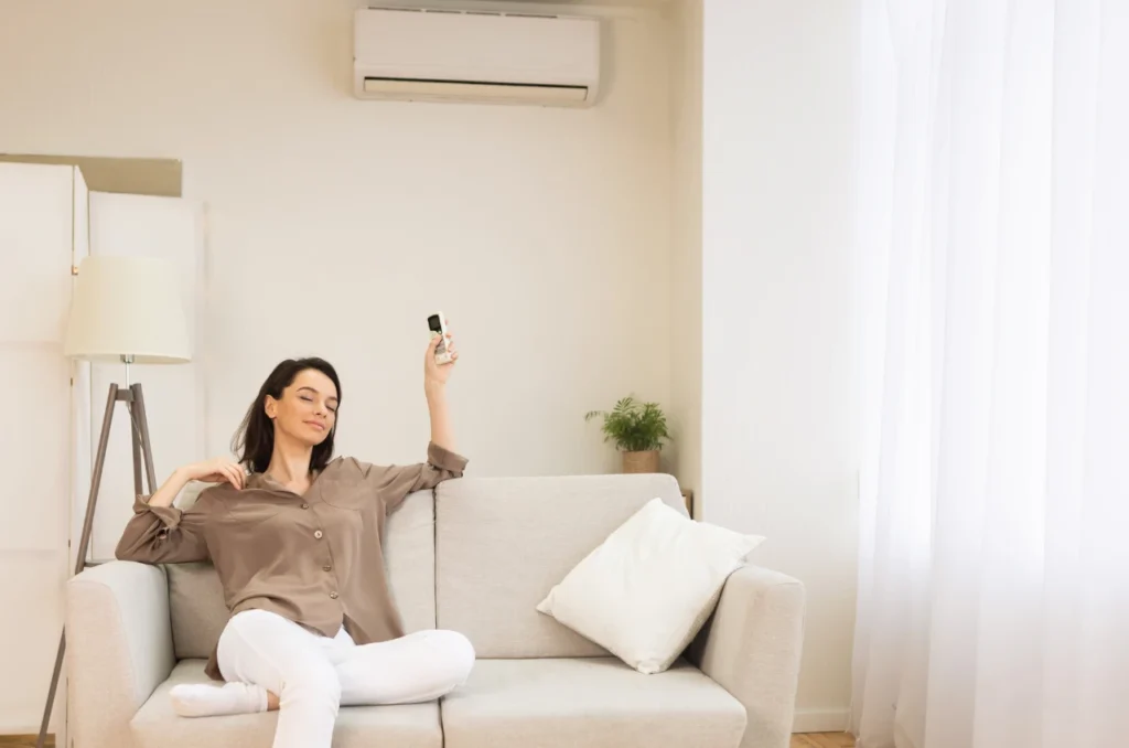 Mulher relaxando no sofa com ar condicionado ligado